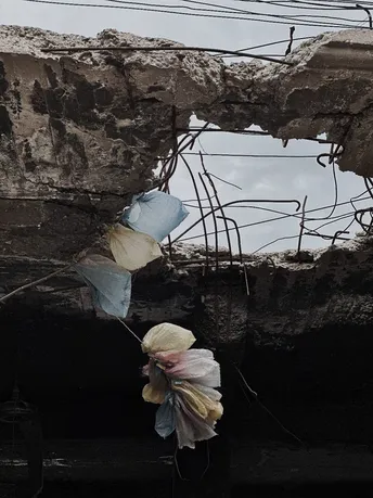 墙上的一个洞 里面挂着塑料袋和花。