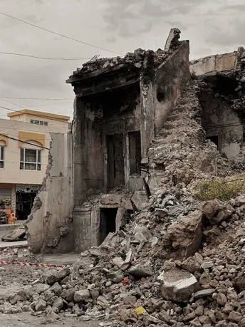 一片被毁的城镇中的一条街道 前方有被毁房屋的瓦砾和碎片。