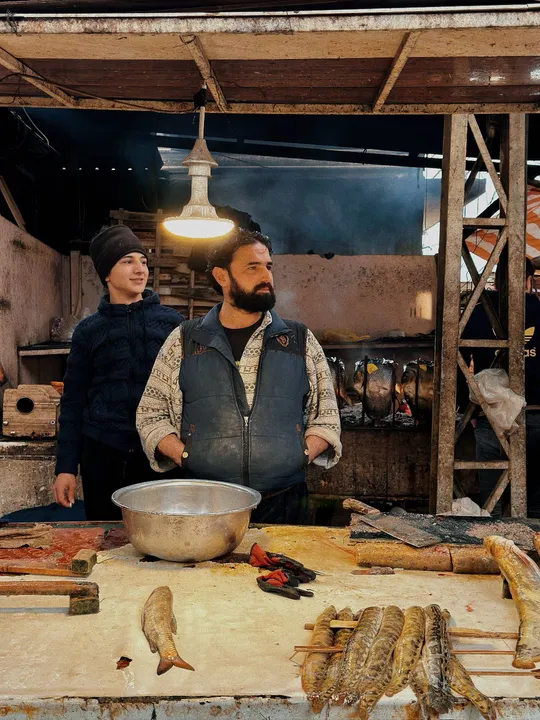 一个站在有鱼在的桌子旁的男子