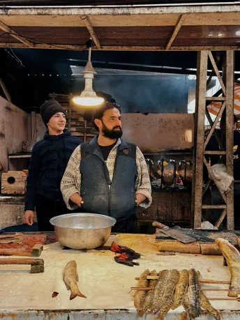 一个站在有鱼在的桌子旁的男子