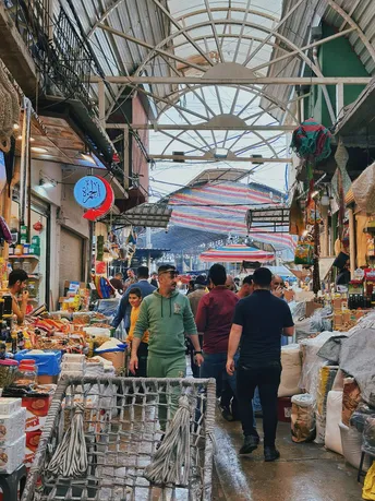 购物者在户外市场的一个过道里走动。