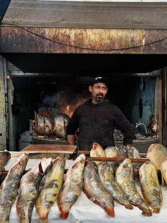 站在鱼摊前的男子