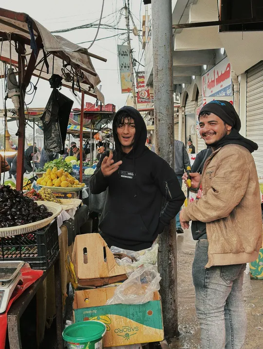 一个男人和一个女人站在一个市场旁边的一条街上。