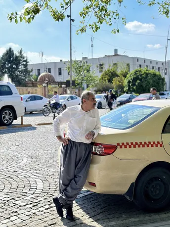 站在街边的一辆汽车旁边的一个男人