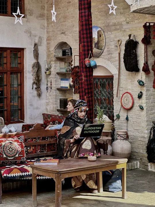 一个男子和一个女子坐在装饰有壁画的房间里的一张沙发上