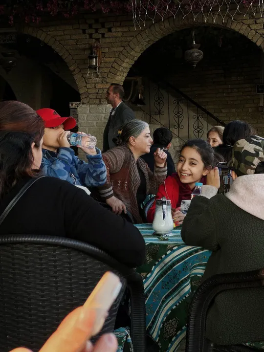 人们在户外桌子旁吃饭