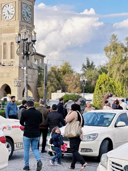 一群人穿越停在汽车旁边的一条街道