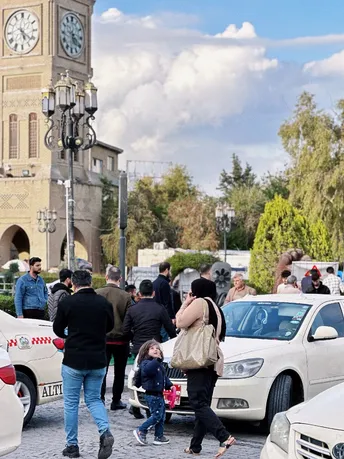 一群人穿越停在汽车旁边的一条街道