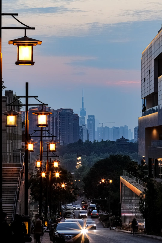 黄昏或夜晚的城市街道 汽车在街上行驶 高楼大厦灯火通明