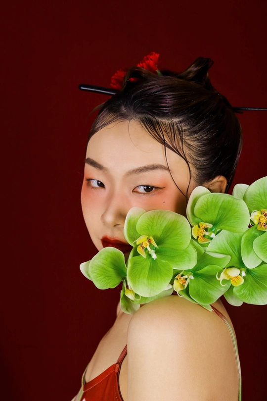 一位年轻女子头戴绿花 为画像摆姿势