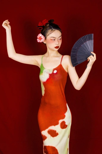 一位穿着红白裙子的女士拿着扇子和雨伞