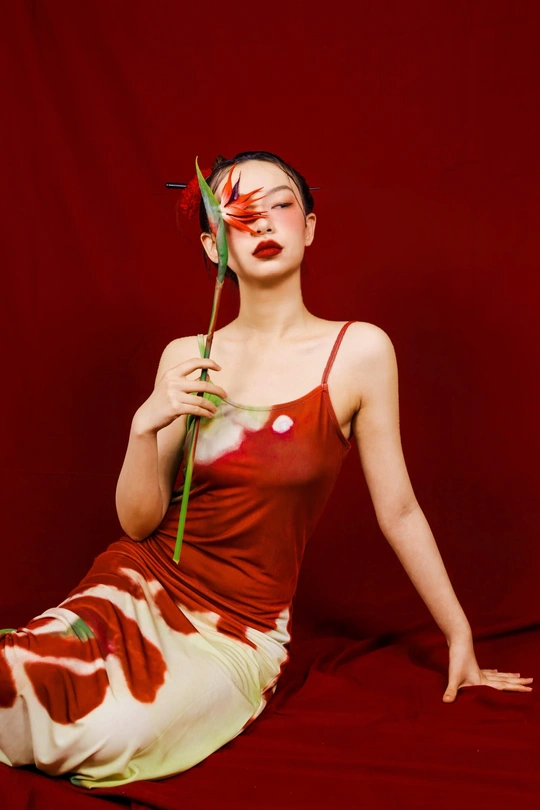 一位穿着红裙子的年轻女子拿着花