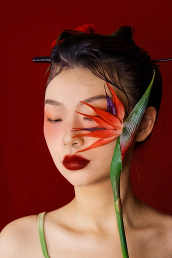 一位年轻女子 绿眼睛 红头发 带着花在脸上 摆姿势