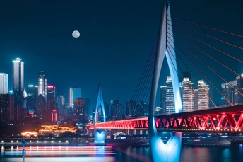 河上的一座桥在夜晚点亮 背景是满月