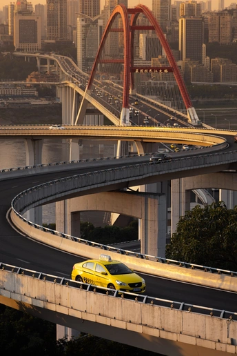 一辆黄色汽车在高速公路上行驶 背景是一座桥