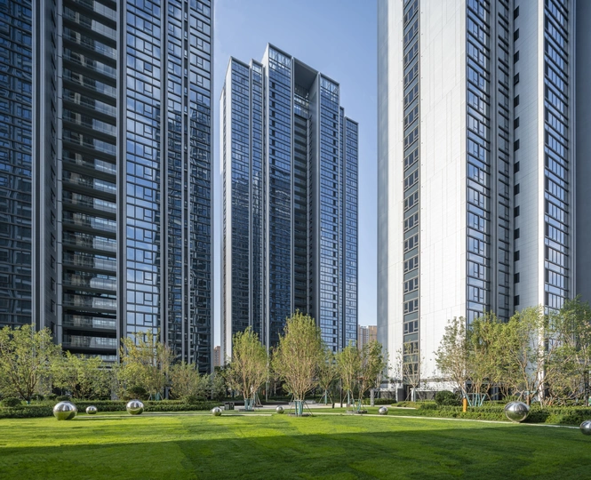 城市前有一片绿草地和树木 后面是高楼大厦。