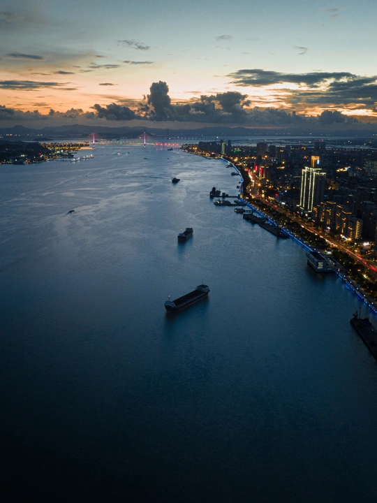 黄昏和日落时水中有船的大城市