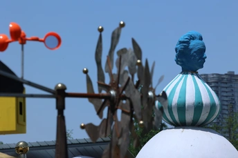 一个坐在建筑物顶端的蓝色男性雕像