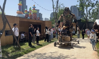 一个人穿着士兵服装站在一辆大车前面 前面有一大群人。