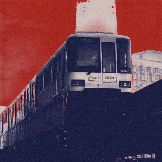 一列火车穿越一座桥 背景是红的天空和一座大型建筑。