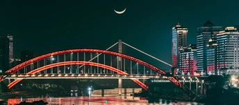 水上的一座大型桥 夜晚被建筑物照亮。