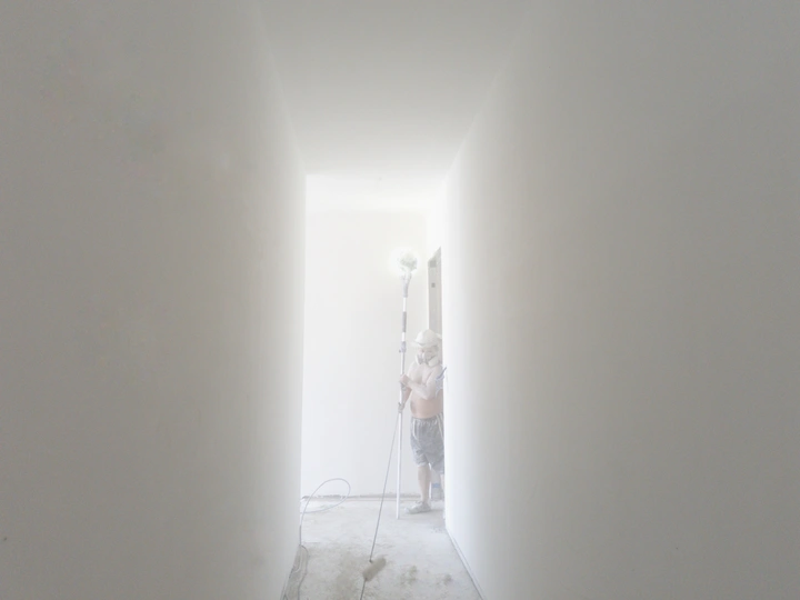 一个人走在一道有白墙的走廊里