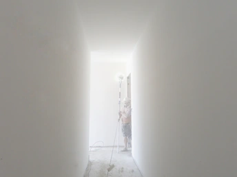 一个人走在一道有白墙的走廊里