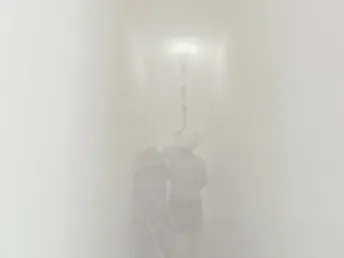 一个人骑自行车穿过雾墙 而另一个人站在摩托车旁边。