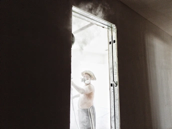 一个人站在一个房间 透过窗户向外看