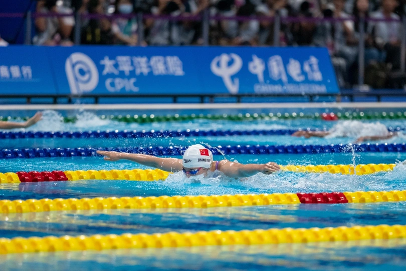 一个人在游泳池里和其他游泳者一起游泳