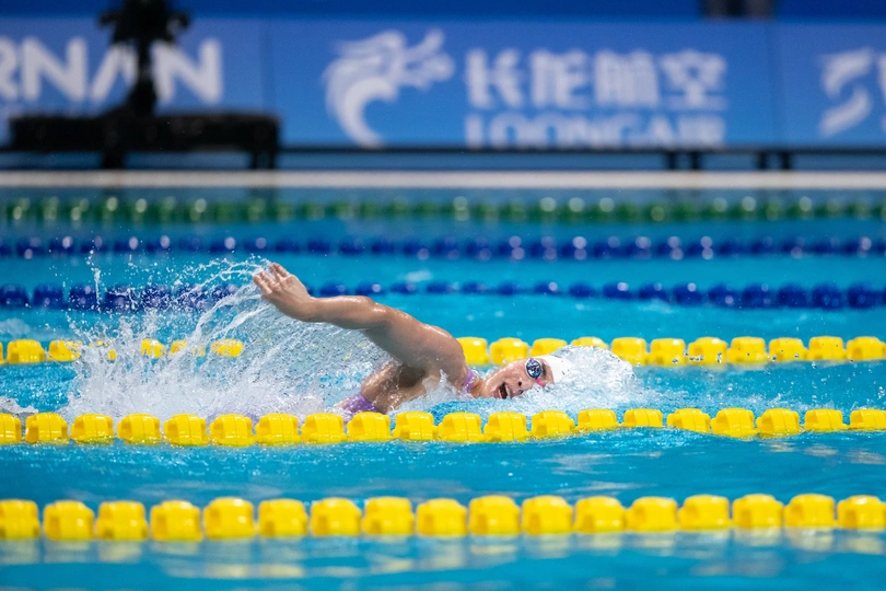 一个人在游泳池里和其他游泳者一起在水中游泳