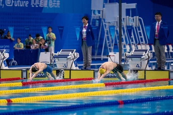 人们在游泳池里观看游泳者