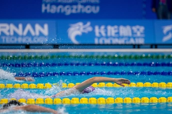 一个人在游泳池里 其他人在水里游泳。