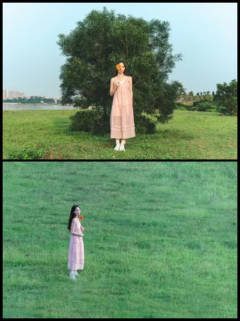 一位穿着粉红色裙子的年轻女子站在一片绿色的草地上 靠近一棵树。