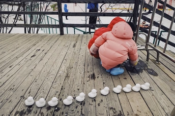 一个坐在覆盖着白雪的甲板上的小男孩