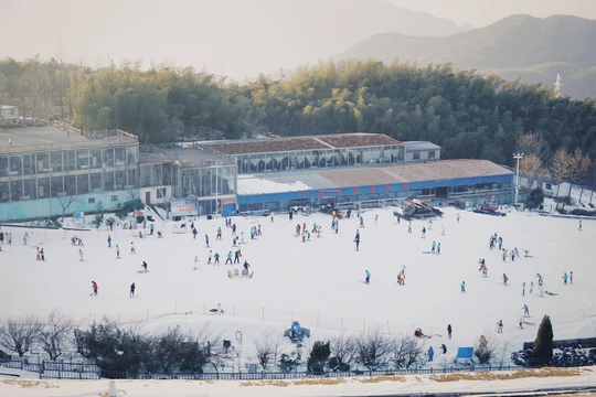 几个人在靠近一座大楼的山坡上滑雪。