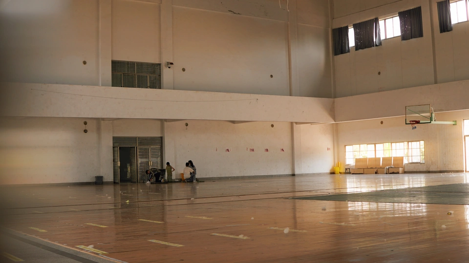 一个空荡荡的大厅 地板上有篮球场。