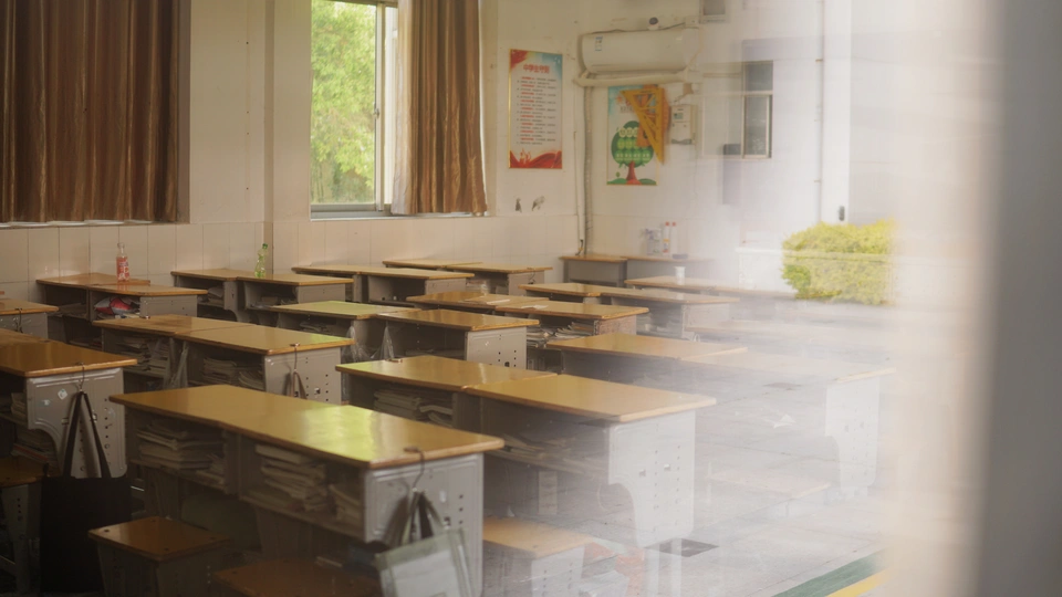 一个充满许多桌子的房间 桌子紧邻着窗户。