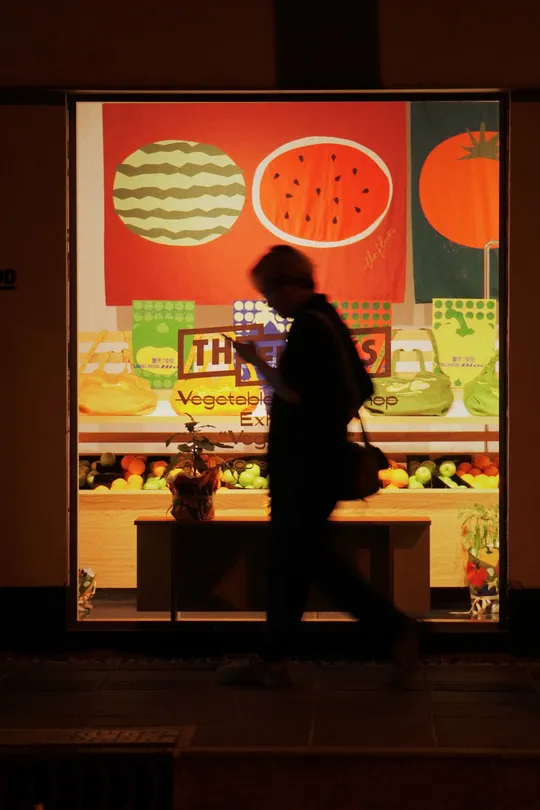 一个男人晚上经过一家商店