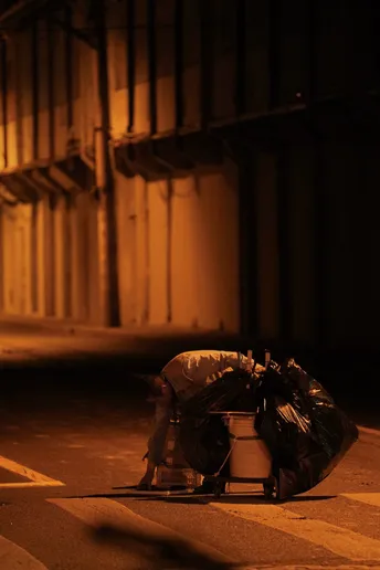 一个人坐在街边一栋建筑物的旁边