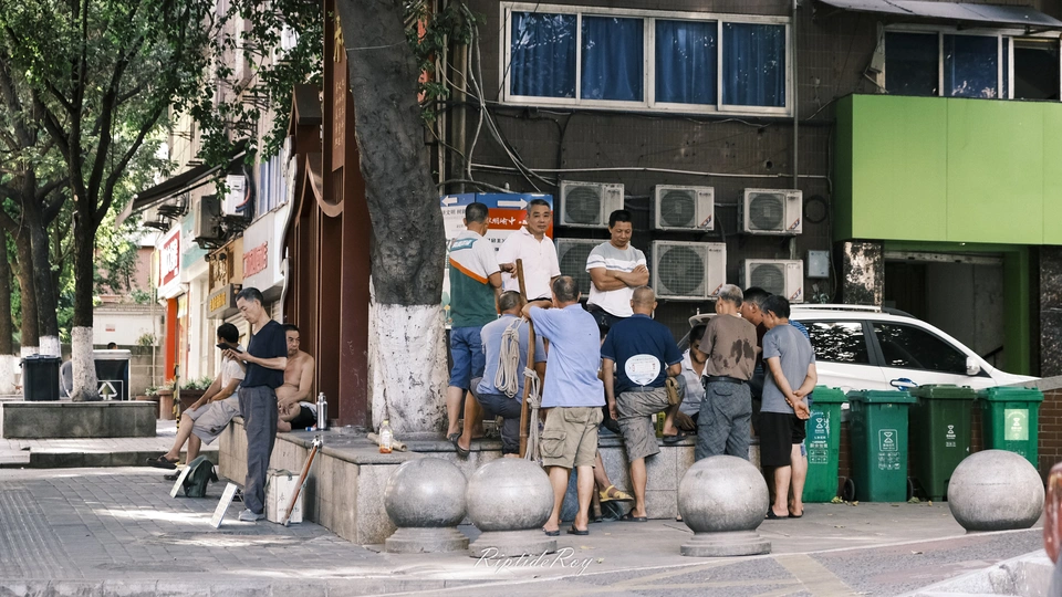 几个人站在一些建筑物附近的人行道上