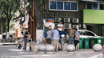 几个人站在一些建筑物附近的人行道上