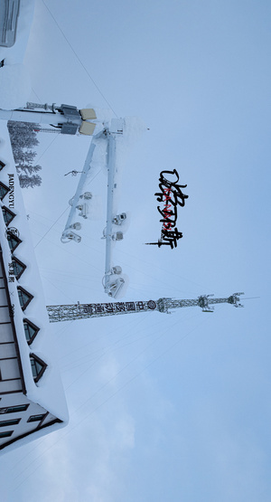 雪中一栋建筑上挂着的一根杆子上的一个标志