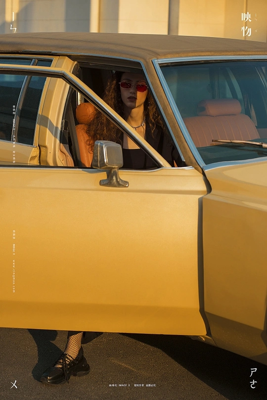 一个坐在黄色汽车里的女人 旁边站着一个小女孩。