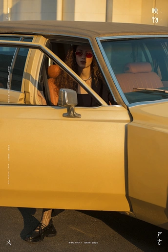 一个坐在黄色汽车里的女人 旁边站着一个小女孩。