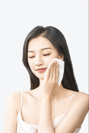 一个年轻女子用一块白毛巾擦脸