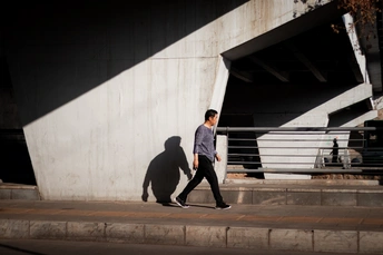 一个年轻男子和女子在桥下人行道上行走 街上的影子