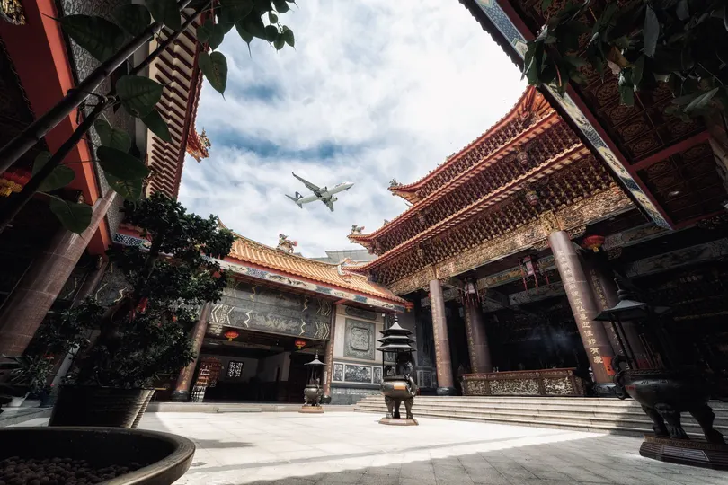 天空上飞行的飞机在大楼上方