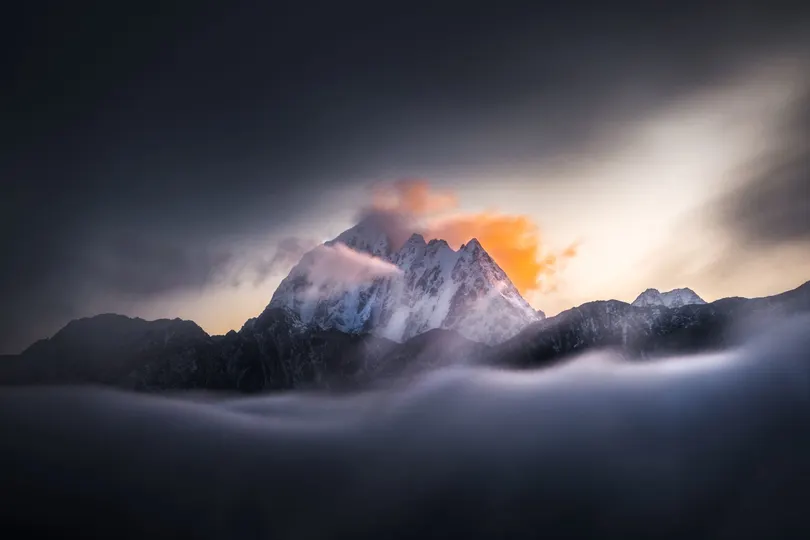 太阳透过山上的雾气和云层