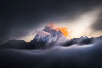 太阳透过山上的雾气和云层